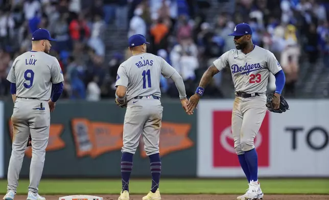 Los Angeles Dodgers right fielder Jason Heyward, right, celebrates with shortstop Miguel Rojas (11) after the team's victory over the San Francisco Giants in a baseball game Saturday, June 29, 2024, in San Francisco. (AP Photo/Godofredo A. Vásquez)