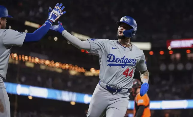 Los Angeles Dodgers' Andy Pages, right, celebrates with Miguel Rojas after scoring against the San Francisco Giants on Jason Heyward's sacrifice fly during the ninth inning of a baseball game Friday, June 28, 2024, in San Francisco. (AP Photo/Godofredo A. Vásquez)
