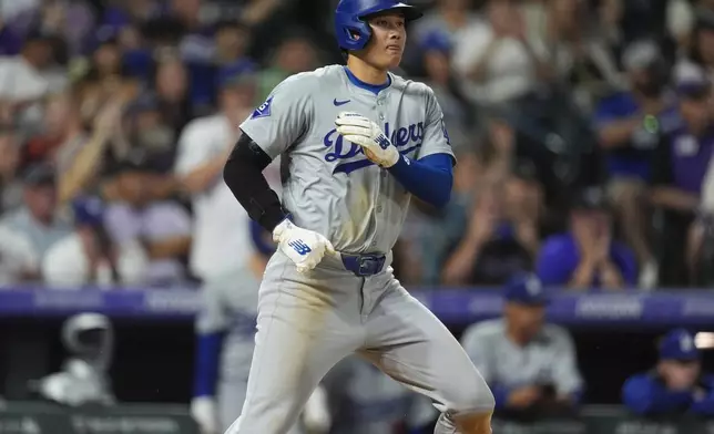 Los Angeles Dodgers' Shohei Ohtani scores on a single hit by Jason Heyward off Colorado Rockies relief pitcher Geoff Hartlieb in the eighth inning of a baseball game Monday, June 17, 2024, in Denver. (AP Photo/David Zalubowski)