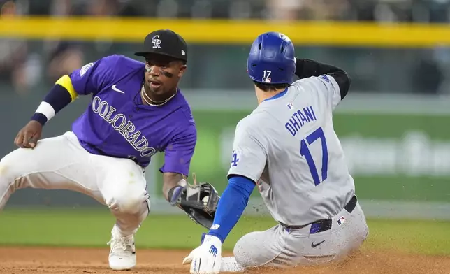 Los Angeles Dodgers' Shohei Ohtani, right, slides safely into second base for a steal as Colorado Rockies second baseman Adael Amador, left, fields the throw in the eighth inning of a baseball game Monday, June 17, 2024, in Denver. (AP Photo/David Zalubowski)