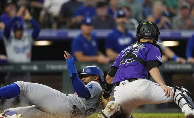 Los Angeles Dodgers' Jason Heyward, left, scores on a double hit by Miguel Rojas as Colorado Rockies catcher Jacob Stallings, right, turns to apply a late tag in the seventh inning of a baseball game Monday, June 17, 2024, in Denver. (AP Photo/David Zalubowski)