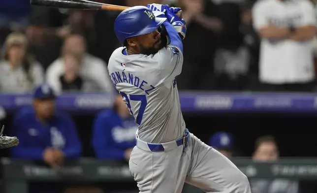 Los Angeles Dodgers' Teoscar Hernández watches his three-run home run off Colorado Rockies relief pitcher Victor Vodnik during the ninth inning of a baseball game Tuesday, June 18, 2024, in Denver. (AP Photo/David Zalubowski)