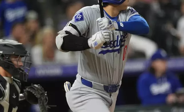 Los Angeles Dodgers' Shohei Ohtani breaks from the batter's box after singling against Colorado Rockies relief pitcher Victor Vodnik during the ninth inning of a baseball game Tuesday, June 18, 2024, in Denver. (AP Photo/David Zalubowski)