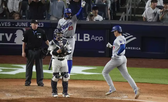Los Angeles Dodgers' Jason Heyward (23) celebrates as Shohei Ohtani, of Japan, runs to home plate to score on a two-run double by Teoscar Hernández as New York Yankees catcher Jose Trevino watches during the eleventh inning of a baseball game, Friday, June 7, 2024, in New York. (AP Photo/Frank Franklin II)