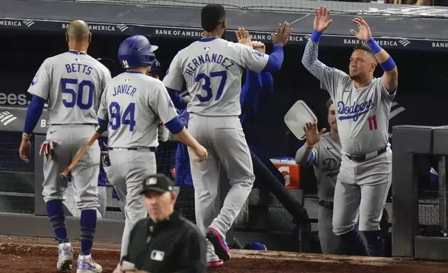 Los Angeles Dodgers' Teoscar Hernández (37) celebrates with teammates after hitting a two-run double during the eleventh inning of a baseball game against the New York Yankees, Friday, June 7, 2024, in New York. (AP Photo/Frank Franklin II)