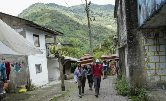 Residents carry coffins of those who died in landslides in El Placer, Ecuador, Monday, June 17, 2024. (AP Photo/Dolores Ochoa)