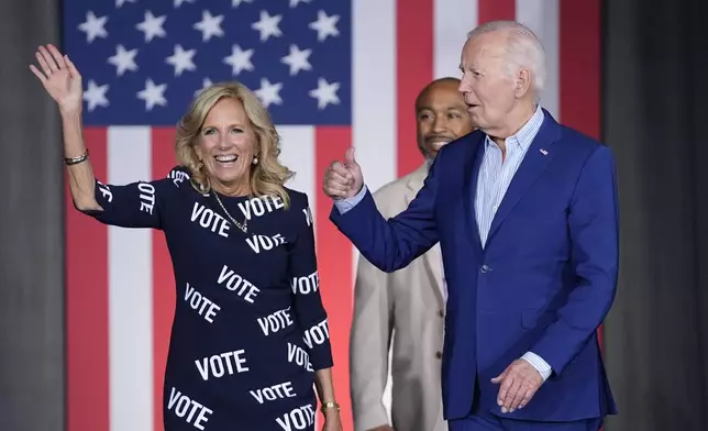 President Joe Biden, right, and first lady Jill Biden, left, walk to the stage to speak at a campaign rally, joined in background by Eric Fitts, Friday, June 28, 2024, in Raleigh, N.C. (AP Photo/Evan Vucci)