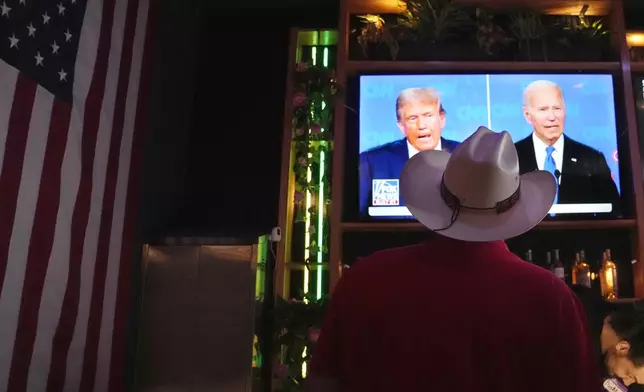 Roger Strassburg, of Scottsdale, Ariz., wears a cowboy hat as he watches the presidential debate between President Joe Biden and Republican presidential candidate former President Donald Trump at a debate watch party Thursday, June 27, 2024, in Scottsdale, Ariz. (AP Photo/Ross D. Franklin)