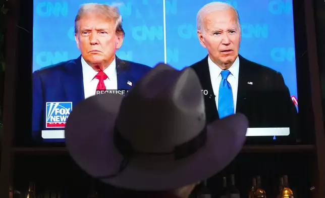 Roger Strassburg, of Scottsdale, Ariz., wears a cowboy hat as he watches the presidential debate between President Joe Biden and Republican presidential candidate former President Donald Trump at a debate watch party Thursday, June 27, 2024, in Scottsdale, Ariz. (AP Photo/Ross D. Franklin)