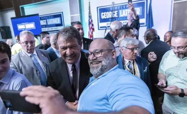 Westchester County Executive George Latimer takes a photo with his supporter at his election night party in White Plains, NY, Tuesday, June 25, 2024. (AP Photo/Jeenah Moon)