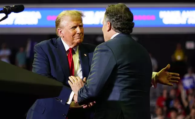 Republican presidential candidate former President Donald Trump, left, greets Republican Senate candidate Dave McCormick at a campaign rally, Saturday, June 22, 2024, at Temple University in Philadelphia. (AP Photo/Chris Szagola)