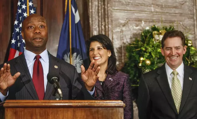 FILE - Rep. Tim Scott, from left, speaks to reporters at the South Carolina Statehouse after being officially introduced by Gov. Nikki Haley to fill the vacant U.S. Senate seat vacated by departing U. S. Sen. Jim DeMint, Dec. 17, 2012, in Columbia. Scott's life has been a series of people offering a hand that helped him get ahead. Now the senator from South Carolina waits to see if former President Donald Trump gives him another boost and makes him the vice presidential nominee. (Tim Dominick/The State via AP, File)