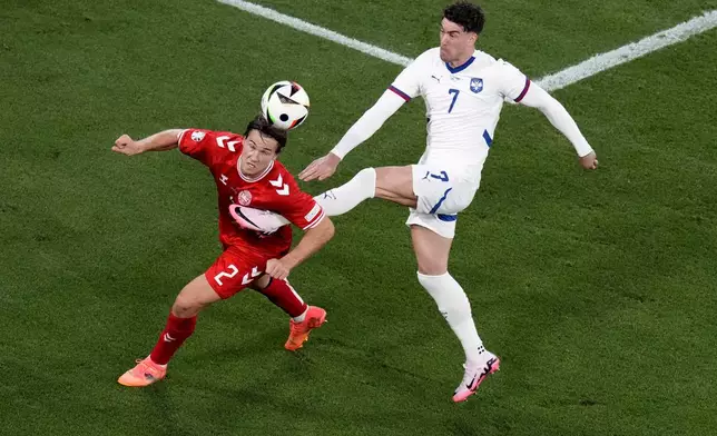 Denmark's Joachim Andersen, left, and Serbia's Dusan Vlahovic challenge for the ball during a Group C match between the Denmark and Serbia at the Euro 2024 soccer tournament in Munich, Germany, Tuesday, June 25, 2024. (AP Photo/Ariel Schalit)