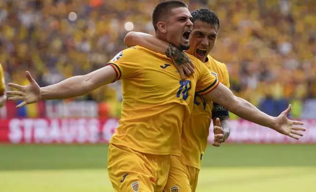 Romania's Razvan Marin, front, celebrates after scoring his side's first goal against Slovakia during a Group E match at the Euro 2024 soccer tournament in Frankfurt, Germany, Wednesday, June 26, 2024. (AP Photo/Themba Hadebe)