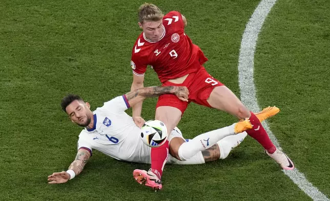 Denmark's Rasmus Hojlund, right, and Serbia's Nemanja Gudelj challenge for the ball during a Group C match between the Denmark and Serbia at the Euro 2024 soccer tournament in Munich, Germany, Tuesday, June 25, 2024. (AP Photo/Ariel Schalit)