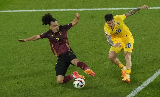 Romania's Dennis Man kicks past Belgium's Arthur Theateduring a Group E match between Belgium and Romania at the Euro 2024 soccer tournament in Cologne, Germany, Saturday, June 22, 2024. (AP Photo/Frank Augstein)