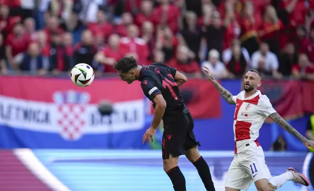 Albania's Qazim Laci, left, heads the ball past Croatia's Marcelo Brozovic to score the opening goal during a Group B match between Croatia and Albania at the Euro 2024 soccer tournament in Hamburg, Germany, Wednesday, June 19, 2024. (AP Photo/Ebrahim Noroozi)