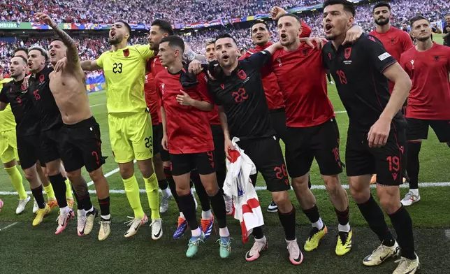 Albania's players celebrate after a Group B match between Croatia and Albania at the Euro 2024 soccer tournament in Hamburg, Germany, Wednesday, June 19, 2024. (Sina Schuldt/dpa via AP)