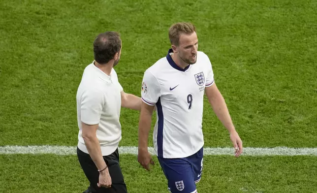 England's Harry Kane walks to the bench past England's manager Gareth Southgate after being substituted during a Group C match between Denmark and England at the Euro 2024 soccer tournament in Frankfurt, Germany, Thursday, June 20, 2024. (AP Photo/Darko Vojinovic)