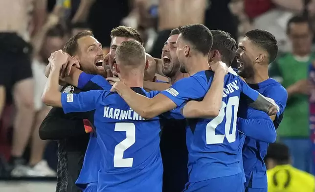 Slovenia's players celebrate after a Group C match against England at the Euro 2024 soccer tournament in Cologne, Germany, Tuesday, June 25, 2024. (AP Photo/Martin Meissner)