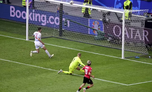 Georgia's Saba Lobjanidze, front, fails to score at the end of a Group F match between Georgia and the Czech Republic at the Euro 2024 soccer tournament in Hamburg, Germany, Saturday, June 22, 2024. (Sina Schuldt/dpa via AP)