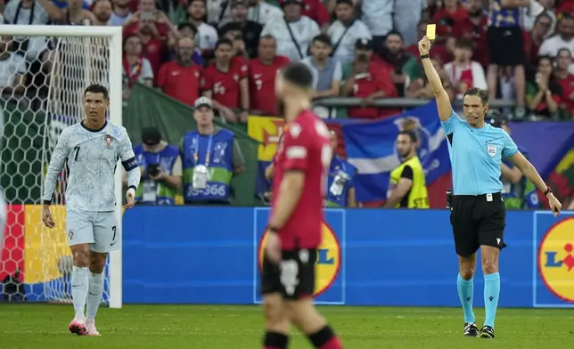 Portugal's Cristiano Ronaldo receives a yellow card from referee Sandro Schärer during a Group F match between Georgia and Portugal at the Euro 2024 soccer tournament in Gelsenkirchen, Germany, Wednesday, June 26, 2024. (AP Photo/Alessandra Tarantino)
