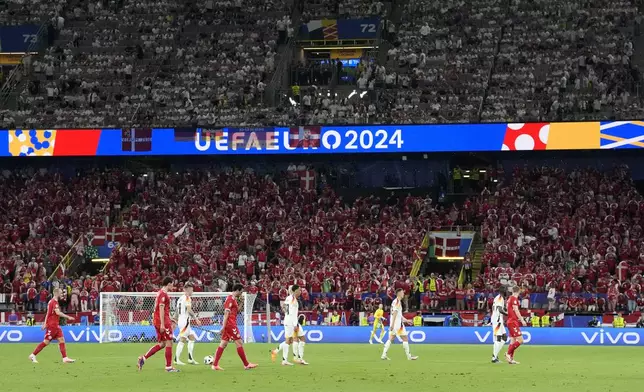 Players leave the pitch after the referee paused the match due to a thunder and lighning storm during the round of sixteen match between Germany and Denmark at the Euro 2024 soccer tournament in Dortmund, Germany, Saturday, June 29, 2024. (AP Photo/Martin Meissner)