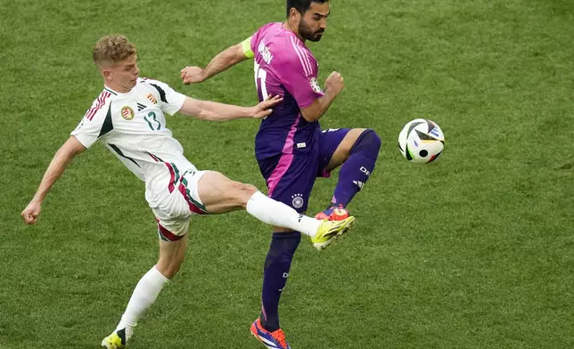 Hungary's Andras Schafer, left, and Germany's Jamal Musiala vie for the ball during a Group A match between Germany and Hungary at the Euro 2024 soccer tournament in Stuttgart, Germany, Wednesday, June 19, 2024. (AP Photo/Themba Hadebe)