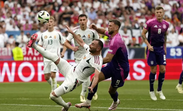 Hungary's Attila Fiola, left, clears the ball ahead of Germany's Niclas Fuellkrug (9) during a Group A match between Germany and Hungary at the Euro 2024 soccer tournament in Stuttgart, Germany, Wednesday, June 19, 2024. (AP Photo/Matthias Schrader)