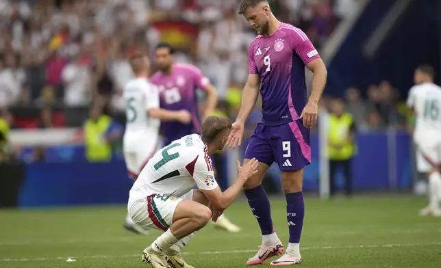 Hungary's Marton Dardai, left, shakes hands with Germany's Niclas Fuellkrug after a Group A match between Germany and Hungary at the Euro 2024 soccer tournament in Stuttgart, Germany, Wednesday, June 19, 2024. (AP Photo/Ariel Schalit)