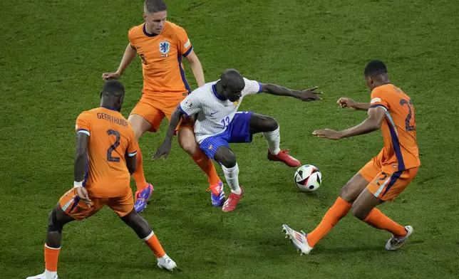 N'Golo Kante of France, center, tries to keep the ball as Denzel Dumfries of the Netherlands, right, Joey Veerman, background, and Lutsharel Geertruida defend against him during a Group D match between the Netherlands and France at the Euro 2024 soccer tournament in Leipzig, Germany, Friday, June 21, 2024. (AP Photo/Sergei Grits)