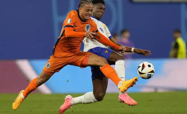 Xavi Simons of the Netherlands, left, is challenged by Aurelien Tchouameni of France during the Group D match between the Netherlands and France at the Euro 2024 soccer tournament in Leipzig, Germany, Friday, June 21, 2024. (AP Photo/Hassan Ammar)