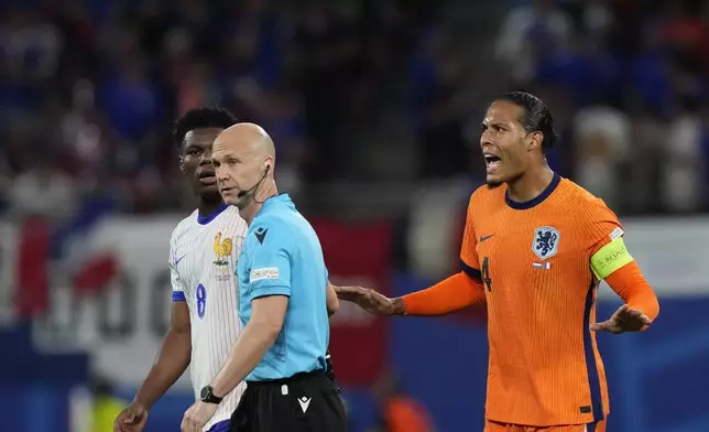 Virgil van Dijk of the Netherlands, right, protest to the referee Anthony Taylor of England, after a goal scored by a teammate was disallowed during a Group D match between the Netherlands and France at the Euro 2024 soccer tournament in Leipzig, Germany, Friday, June 21, 2024. (AP Photo/Mathias Schrader)