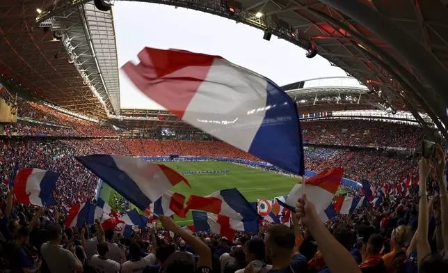 French supporter wave French flags before the Group D match between the Netherlands and France at the Euro 2024 soccer tournament in Leipzig, Germany, Friday, June 21, 2024. (Robert Michael/dpa via AP)