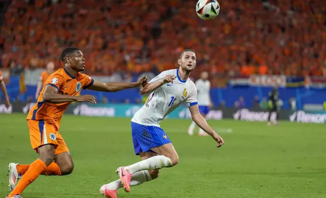 Denzel Dumfries of the Netherlands, left, duels for the ball with Adrien Rabiot of France during a Group D match between the Netherlands and France at the Euro 2024 soccer tournament in Leipzig, Germany, Friday, June 21, 2024. (AP Photo/Ariel Schalit)