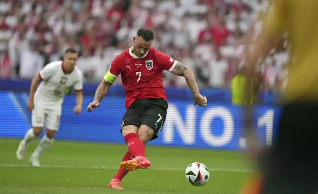 Austria's Marko Arnautovic (7) scores from the penalty spot during a Group D match between Poland and Austria at the Euro 2024 soccer tournament in Berlin, Germany, Friday, June 21, 2024. (AP Photo/Sunday Alamba)