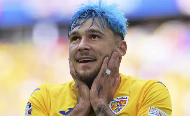 Romania's Andrei Ratiu smiles during a Group E match between Romania and Ukraine at the Euro 2024 soccer tournament in Munich, Germany, Monday, June 17, 2024. (Peter Kneffel/dpa via AP)