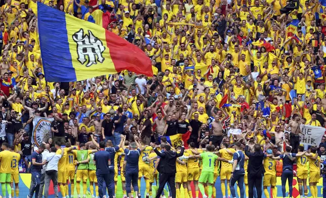 Romania team members celebrate in front of their fans after winning the Group E match between Romania and Ukraine at the Euro 2024 soccer tournament in Munich, Germany, Monday, June 17, 2024. (Peter Kneffel/dpa via AP)