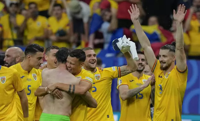 Romania's players celebrate at the end of the match during a Group E match between Slovakia and Romania at the Euro 2024 soccer tournament in Frankfurt, Germany, Wednesday, June 26, 2024. (AP Photo/Frank Augstein)