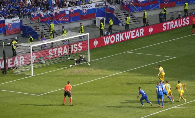 Romania's Razvan Marin (18), scores from the penalty spot, his side's first goal against Slovakia, during a Group E match at the Euro 2024 soccer tournament in Frankfurt, Germany, Wednesday, June 26, 2024. (AP Photo/Darko Vojinovic)