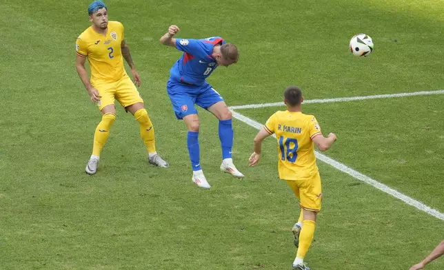 Slovakia's Ondrej Duda heads the ball to score his team's opening goal against Romania during a Group E match at the Euro 2024 soccer tournament in Frankfurt, Germany, Wednesday, June 26, 2024. (AP Photo/Darko Vojinovic)