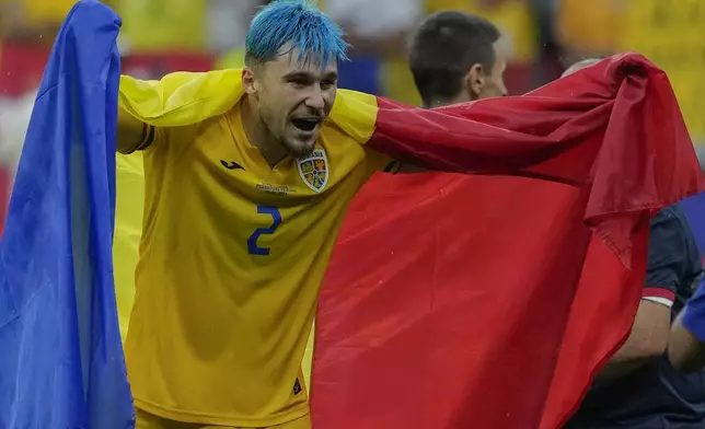 Romania's Andrei Ratiu celebrates at the end of the match during a Group E match between Slovakia and Romania at the Euro 2024 soccer tournament in Frankfurt, Germany, Wednesday, June 26, 2024. (AP Photo/Frank Augstein)