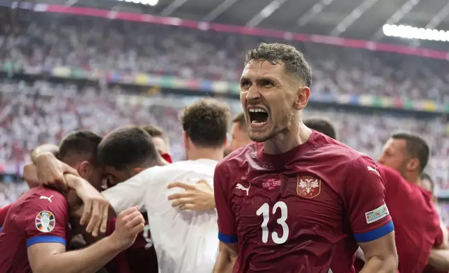 Serbia's Milos Veljkovic, right, celebrates with teammates his side first goal against Slovenia during a Group C match between Slovenia and Serbia at the Euro 2024 soccer tournament in Munich, Germany, Thursday, June 20, 2024. (AP Photo/Matthias Schrader)