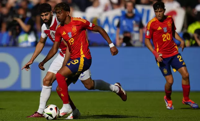 Spain's Lamine Yamal, center, runs with the ball next to Croatia's Josko Gvardiol during to a Group B match between Spain and Croatia at the Euro 2024 soccer tournament in Berlin, Germany, Saturday, June 15, 2024. (AP Photo/Manu Fernandez)