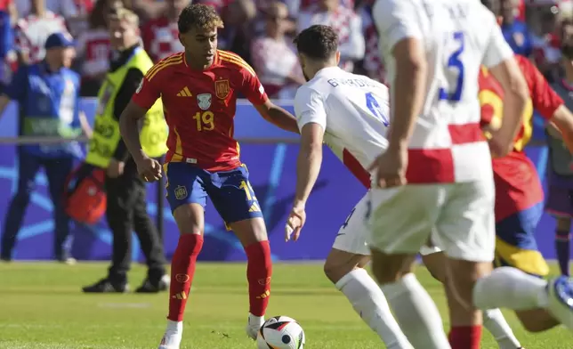 Spain's Lamine Yamal, left, plays the ball during a Group B match between Spain and Croatia at the Euro 2024 soccer tournament in Berlin, Germany, Saturday, June 15, 2024. Lamine Yamal was set to become the youngest player ever to play at a European Championship on Saturday when he was named in Spain's starting lineup for its Group B-opening game against Croatia. (Soeren Stache/dpa via AP)