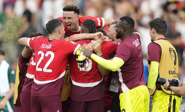 Switzerland players embrace after a round of sixteen match between Switzerland and Italy at the Euro 2024 soccer tournament in Berlin, Germany, Saturday, June 29, 2024. (AP Photo/Ebrahim Noroozi)