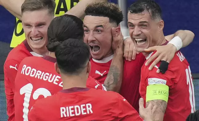 Switzerland's Ruben Vargas, center, celebrates with teammates after scoring his side's second goal during a round of sixteen match between Switzerland and Italy at the Euro 2024 soccer tournament in Berlin, Germany, Saturday, June 29, 2024. (Soeren Stache/dpa via AP)