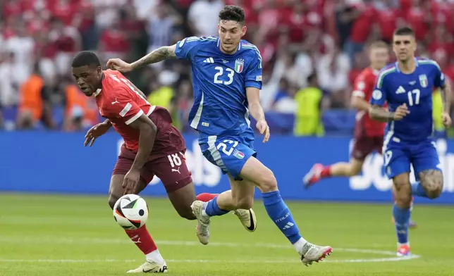 Italy's Alessandro Bastoni vies for the ball with Switzerland's Kwadwo Duah, left, during a round of sixteen match between Switzerland and Italy at the Euro 2024 soccer tournament in Berlin, Germany, Saturday, June 29, 2024. (AP Photo/Antonio Calanni)