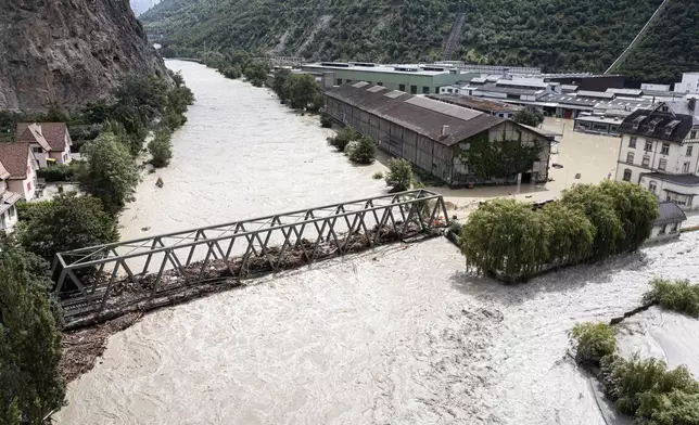 A view of the Rhone river, at right, and the Navizence river overflowing, following the storms that caused major flooding, in Chippis, Switzerland, Sunday, June 30, 2024. The Rhone river burst its banks in several areas of Valais canton, flooding a highway and a railway line. (Olivier Maire/Keystone via AP)