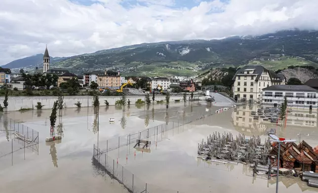 The Navizence river, are overflowing in the industrial zone produces aluminium "Constellium" following the storms that caused major flooding, in Chippis, Switzerland, Sunday, June 30, 2024. The Rhone river burst its banks in several areas of Valais canton, flooding a highway and a railway line. (Olivier Mairet/Keystone via AP)